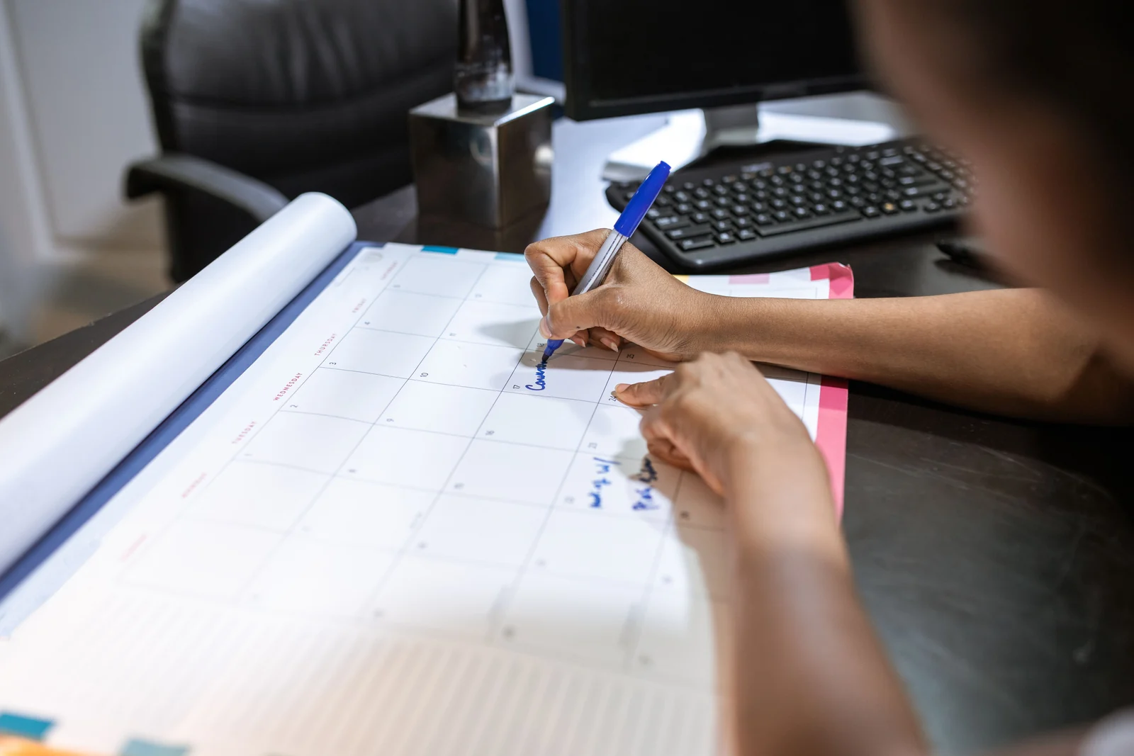 Planning a working schedule on a desk calendar