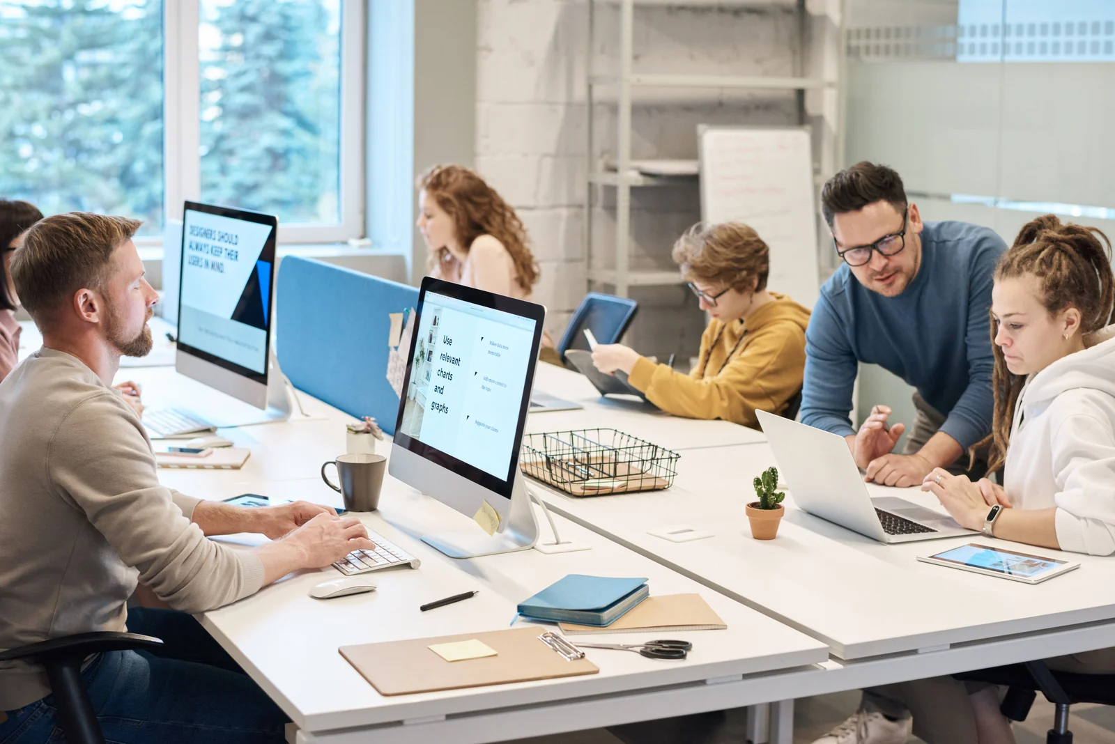 Colleagues working at shared desks in a bright office